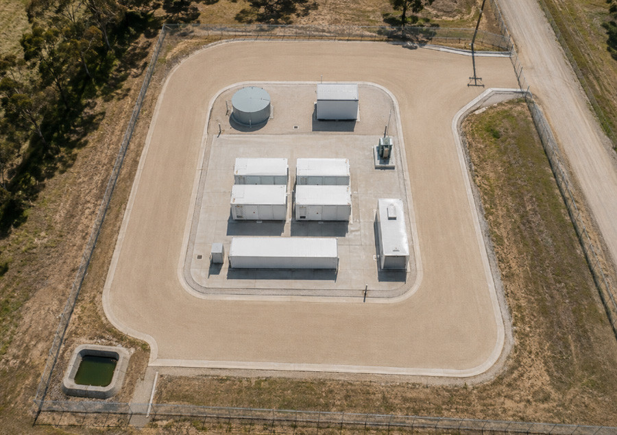 Overhead view of a compact battery compound with a gravel apron and drainage basin